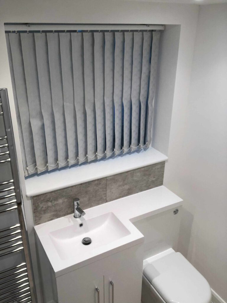 Fitted bathroom sink, toilet and under sink cupboard. White tops.